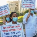 Работники израильский медлабораторий с плакатами, на которых нанесен призыв к правительству: "Проснитесь". Ph.:Yehoshua Yosef