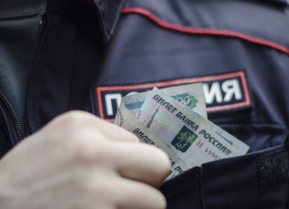 Полицейский прячет деньги в карман